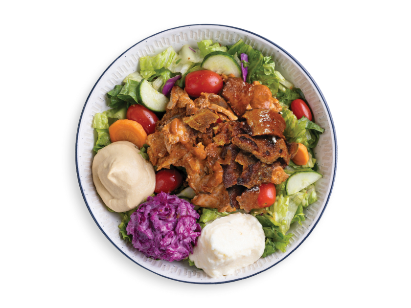 Chicken shawarma and gyro salad bowl with romaine, vegetables, herbs and dressing