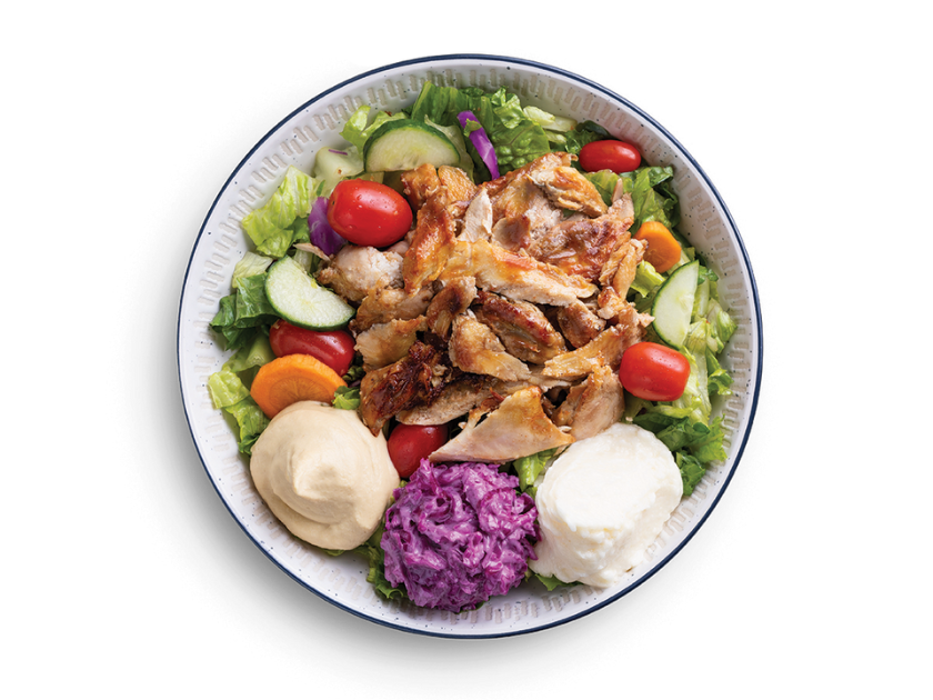 Chicken shawarma salad bowl with romaine, tomatoes, cucumbers, peppers, cabbage, feta, herbs and pita