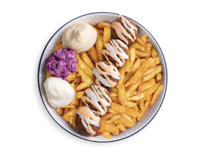 Falafel served over fries with turnips, hummus, tahini, parsley, tomatoes and lettuce