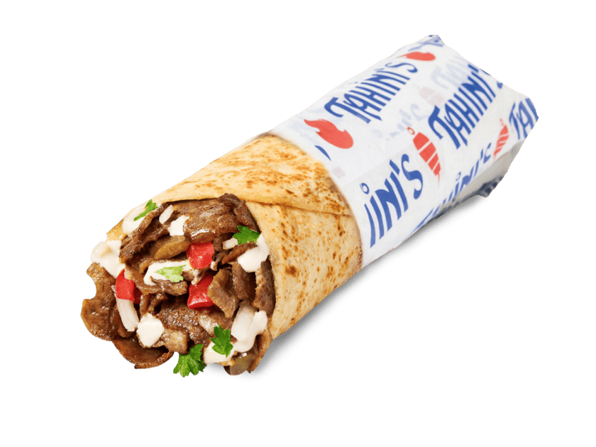 Sliced beef shawarma wrap rolled in saj bread with onions, pita chips, turnips, hummus, tahini, parsley and tomatoes